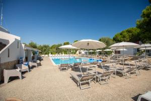 a group of chairs and umbrellas next to a swimming pool at Centro Vacanze Piccolo Friuli in Vieste