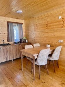 comedor con mesa de madera y sillas en Twin cottages kazbegi 2 en Kazbegi