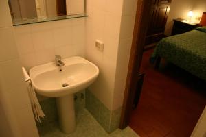 a bathroom with a white sink and a bed at B&B Casale Virgili in Siena