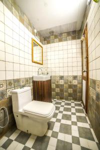 a bathroom with a toilet and a checkered floor at Xplore Indo - Glamping Villa in Napoklu