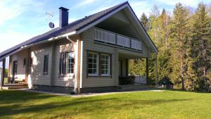 a small wooden house with a grassy yard at Keskikosken Lomamökit in Venäjänjärvi