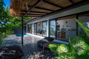 an outdoor patio with chairs and a house at Lunar Villas Koh Tao - Luxury Private Pool Villas in Koh Tao