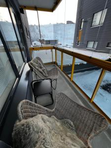 un balcon avec un lit et deux chaises sur un bateau dans l'établissement Levin Kunkku C4, à Levi 12 autres photos