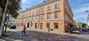 two people standing on a street in front of a building at TyzenXL Luxury Vilnius Apartments in Vilnius