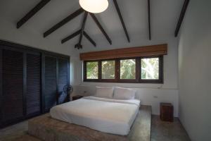 a bedroom with a white bed and a large window at Lunar Villas Koh Tao - Luxury Private Pool Villas in Ko Tao