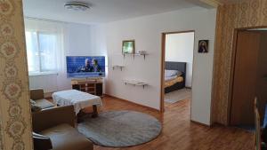 a living room with a television and a bedroom at Apartament Marly Cathedral in Gura Humorului