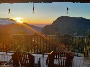 einen Tisch mit Blick auf die Berge bei Sonnenuntergang in der Unterkunft Golden View Guest in Ella