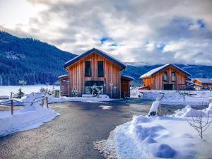 um par de edifícios com neve à volta deles em Chalet Bellevue Murau em Murau