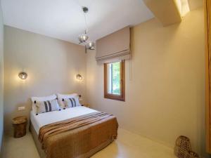 a bedroom with a bed and a window at Holly Tree - Tsagarada Pelion in Tsagarada