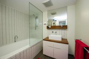 耐莉湾Panoramic Ocean Views 2 bed/2 bath Unit, Nelly Bay的带浴缸、水槽和淋浴的浴室