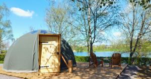 Tienda con sillas y mesa frente a un lago en Bulle de l'étang - Etat Nature en Magnières