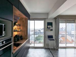 a kitchen with a view of a balcony at Hyper Centre La Roche sur Yon - Appartement spacieux et lumineux in La Roche-sur-Yon +9 photos