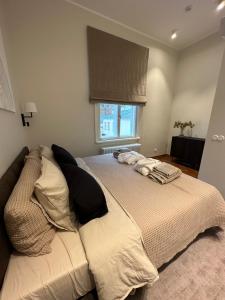a bedroom with a bed with pillows and a window at Luxurious Vallikraavi apartment with Sauna, free parking in Tartu