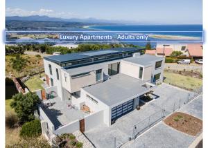 uma vista aérea de uma casa com o oceano ao fundo em Hilltop Bayview Luxury Apartments em Plettenberg Bay