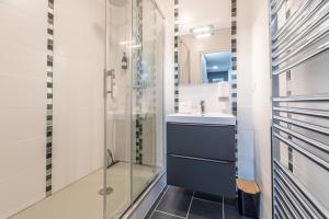 a bathroom with a sink and a glass shower at F2 "Paris Jaude " Clermont Fd in Clermont-Ferrand +22 photos