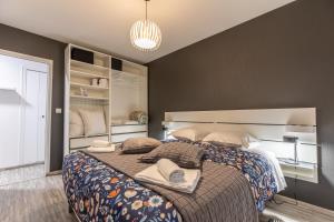 a bedroom with a large bed with pillows on it at F2 "Paris Jaude " Clermont Fd in Clermont-Ferrand