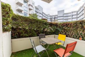 a table and chairs in a garden with buildings at F2 "Paris Jaude " Clermont Fd in Clermont-Ferrand