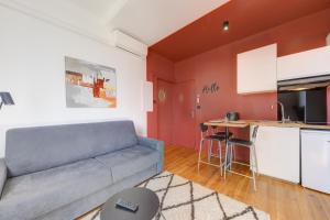 sala de estar con sofá y cocina en Terracotta-T2-Clim-Parking gratuit privé, en Pierre-Bénite