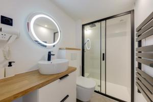 Baño blanco con lavabo y espejo en Terracotta-T2-Clim-Parking gratuit privé, en Pierre-Bénite