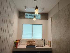 a kitchen with a sink and a window at GreenHouse EcoLodge in Mantanani Island 