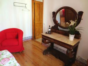ein Wohnzimmer mit einem roten Stuhl und einem Spiegel in der Unterkunft Casa da Villa 1C in Sintra
