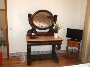 tocador con espejo y TV en Casa da Villa 1C, en Sintra