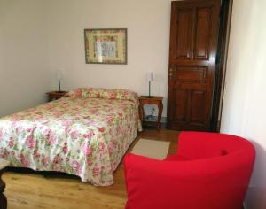 - une chambre avec un lit et une chaise rouge dans l'établissement Casa da Villa 1C, à Sintra