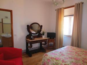 um quarto com um espelho e uma secretária com uma cama em Casa da Villa 1C em Sintra
