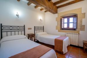 a bedroom with two beds and a window in it at Apartamentos El Lagar de Somo in Somo