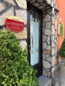 eine Tür zu einem Gebäude mit einem Schild darauf in der Unterkunft La Tavernetta in Pignola