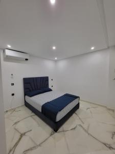 a bedroom with a bed in a white room at Duplex+2 salles de bain à 5 min de l'aéroport in Marrakech +9 photos