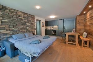 een slaapkamer met een bed en een stenen muur bij Z Suite Zermatt in Zermatt