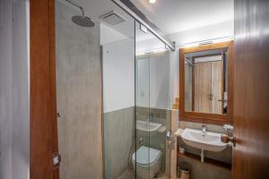 een badkamer met een wastafel, een toilet en een spiegel bij Hotel Onrock in Ella