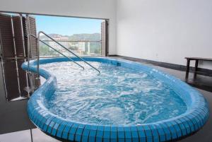 a large blue hot tub in a room with a window at Serene Muji Family Cottage(2-7pax) & Sunrise View in Cameron Highlands