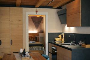 a kitchen with a sink and a bedroom with a bed at Aosta Romana case vacanza in Aosta