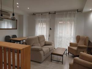 uma sala de estar com um sofá, cadeiras e uma mesa em Granada Centro Congresos em Granada