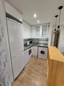 a kitchen with a white refrigerator and a dishwasher at Granada Centro Congresos in Granada