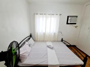 1 dormitorio con 1 cama en una habitación con ventana en Calapan Transient Molave L47, en Calapan