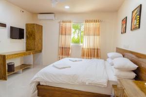 1 dormitorio con 1 cama con sábanas y almohadas blancas en MEHEL - Holiday Home - Mahibadhoo en Mahibadhoo