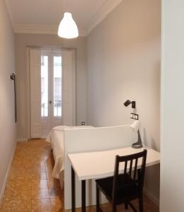 a white room with a table and a bed at Hostal Yolanda in Madrid