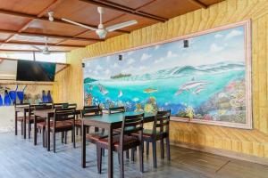 a dining room with a large painting on the wall at MEHEL - Holiday Home - Mahibadhoo in Mahibadhoo