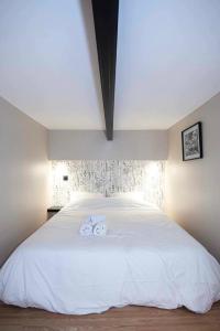 a bedroom with a white bed with two towels on it at Duplex-Université in Lyon