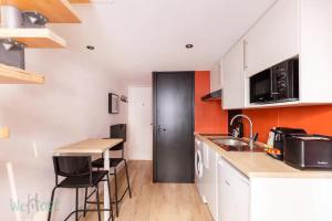 una pequeña cocina con una puerta negra y una mesa en Duplex-Université en Lyon
