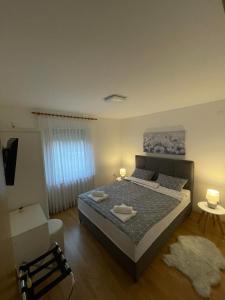 a bedroom with a bed with two lamps on it at Kuća za odmor Saturnus in Karanac