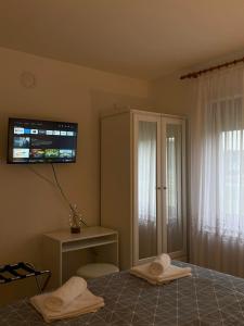 um quarto com uma cama e uma televisão na parede em Kuća za odmor Saturnus em Karanac