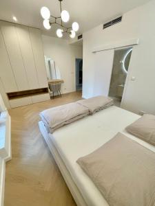 een grote slaapkamer met 2 bedden en een spiegel bij Stylish 3 bedroom apartment in the hearth of city center with history in Bratislava