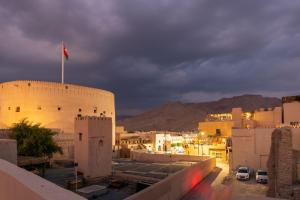 a city with a flag on top of a building at House 76 in Nizwa