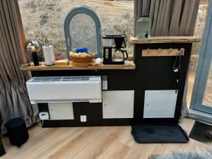 una pequeña cocina con lavabo y espejo en Lofoten glampingdome en Myrland