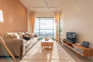 a living room with a couch and a tv at Serene Muji Family Cottage(2-7pax) & Sunrise View in Cameron Highlands