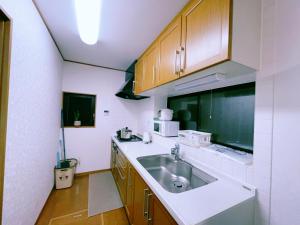 a kitchen with a sink and a microwave at Miyama House in Hachioji
